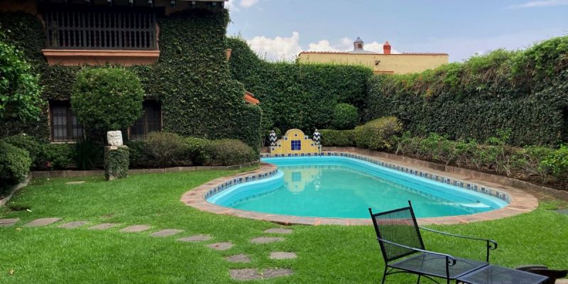 Beautiful pool area with shimmering water, chic outdoor furniture, and a shaded dining space for gatherings